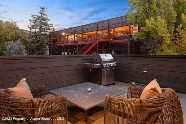 a backyard of a house with barbeque oven and outdoor seating