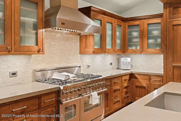 a kitchen with stainless steel appliances granite countertop a sink stove and cabinets