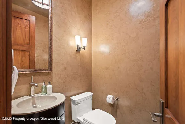 a bathroom with a toilet a sink and mirror