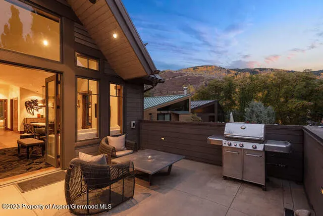 a view of a patio with couches chairs and wooden floor