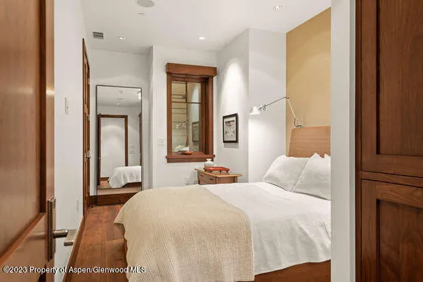 a bedroom with a bed and large windows