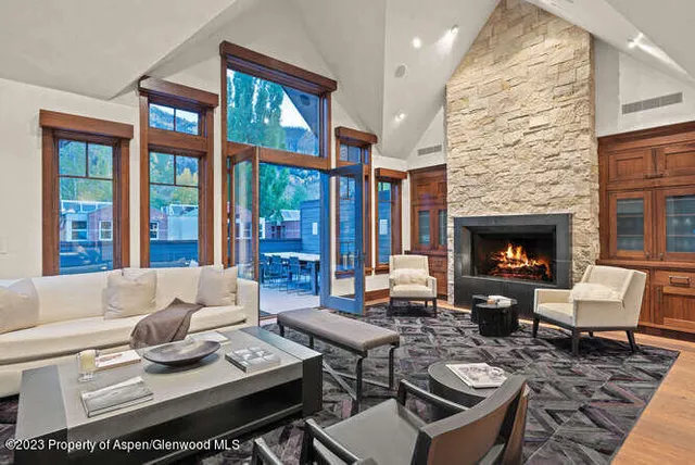 a living room with furniture a fireplace a lamp and a large window