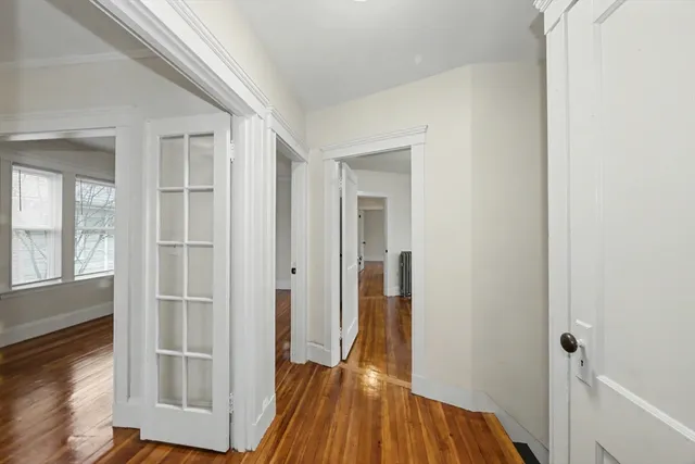 a view of a hallway with wooden floor and entryway