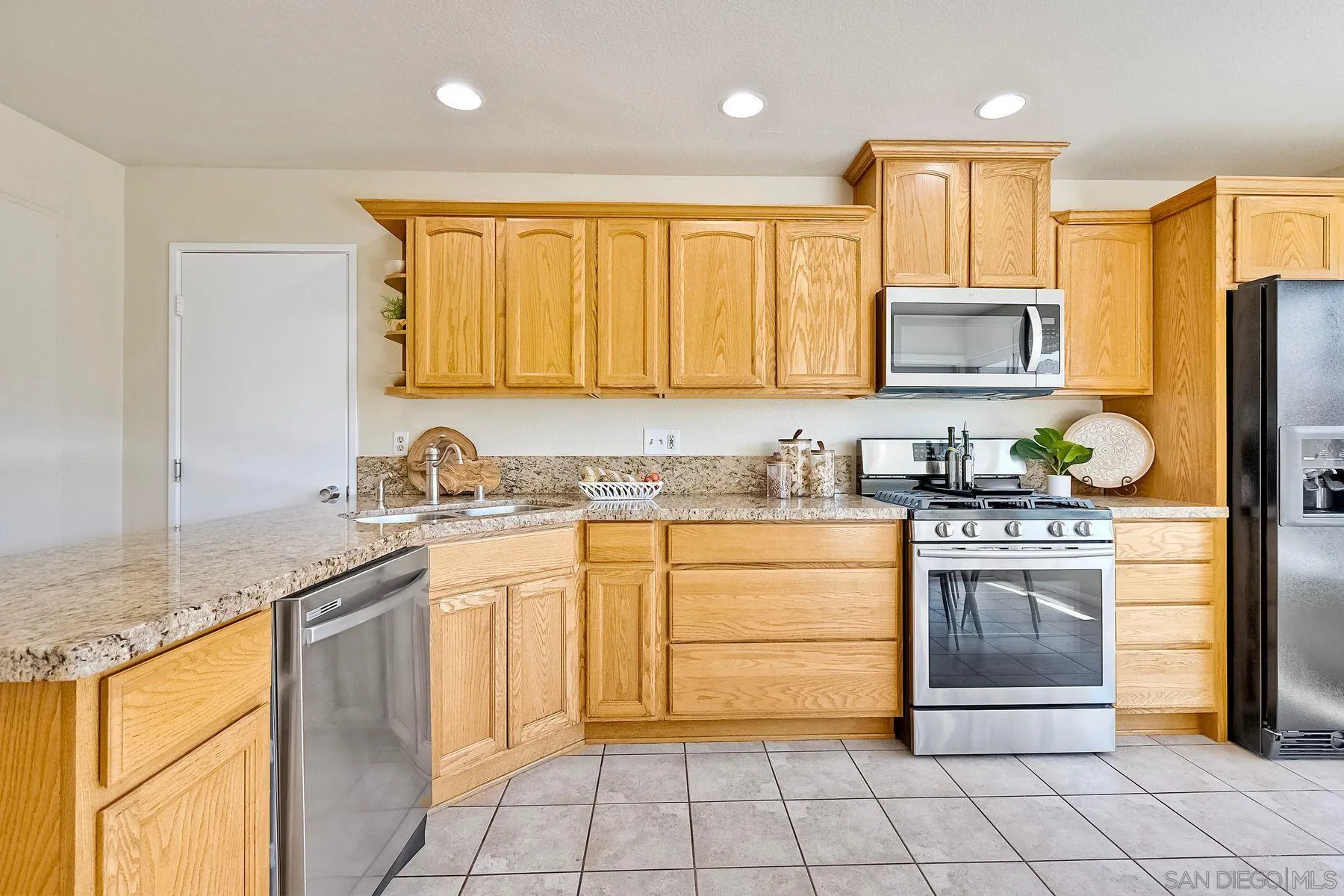 13440 Montego Drive Poway, CA 92064 - Photo 16 of 35 a kitchen with stainless steel appliances granite countertop a stove sink and cabinets