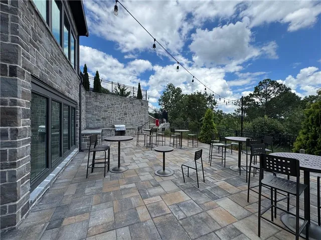 a view of a backyard with brick wall and potted plants