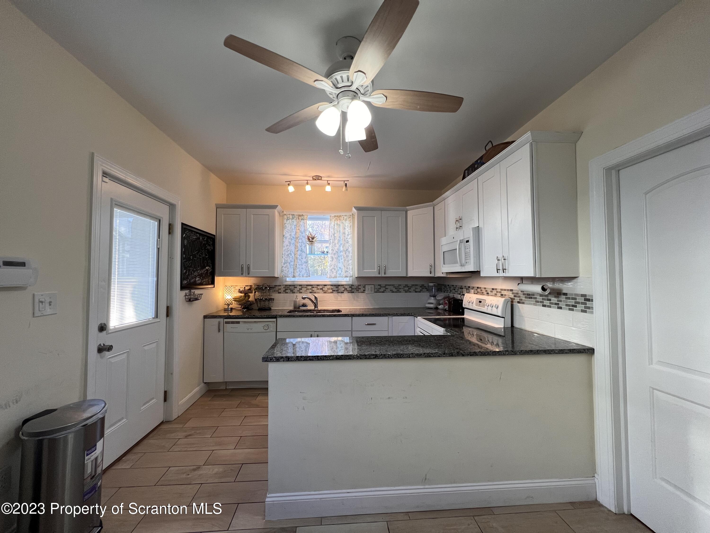 611 East Locust Street Scranton, PA 18505 - Photo 7 of 18 a kitchen with stainless steel appliances granite countertop a sink a stove and a refrigerator