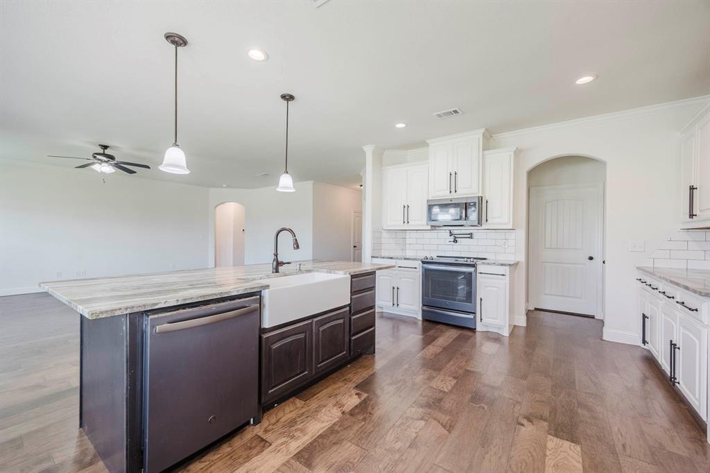 105 Kathy Stephens Avenue Springtown, TX 76082 - Photo 28 of 40 a kitchen with kitchen island a sink stainless steel appliances and cabinets