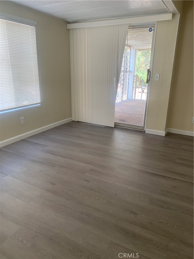 2865 West Rialto Avenue, Unit 2 Rialto, CA 92376 - Photo 17 of 19 an empty room with wooden floor and windows
