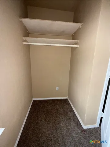 an empty room with a ceiling fan and window