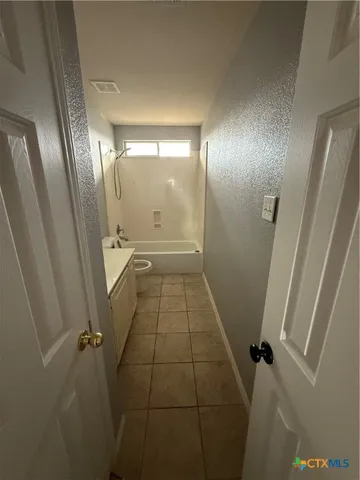 a backyard of a house with table and chairs under an umbrella