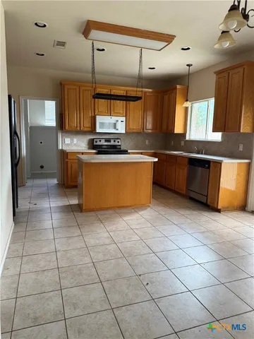 a large kitchen with stainless steel appliances lots of counter top space and cabinets