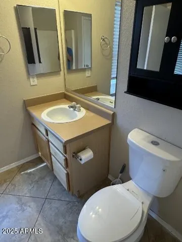 a bathroom with a toilet a sink and mirror