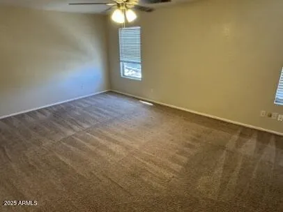an empty room with windows and fan
