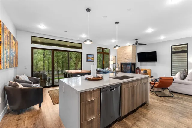 a view of a kitchen with kitchen island granite countertop a sink and a flat screen tv
