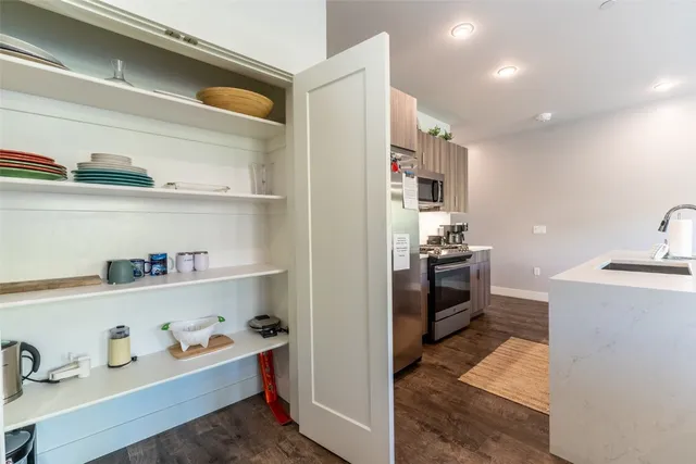 a kitchen with a refrigerator and wooden floor