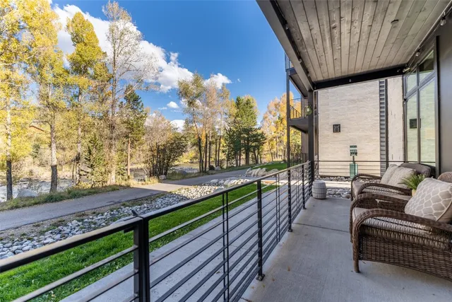a view of a house with wooden deck and trees
