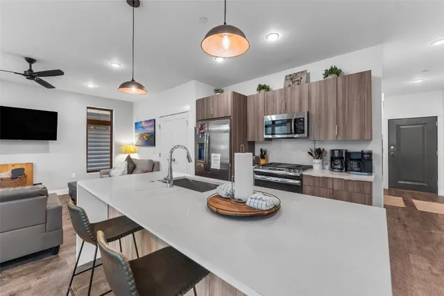 a kitchen with a refrigerator a stove a sink and chairs