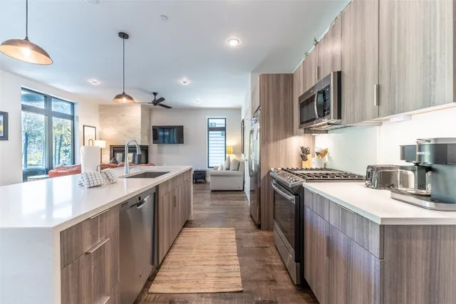 a kitchen with stainless steel appliances granite countertop a sink a stove and a refrigerator