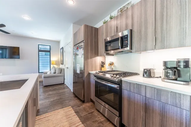 a kitchen with stainless steel appliances granite countertop a stove a sink and a microwave