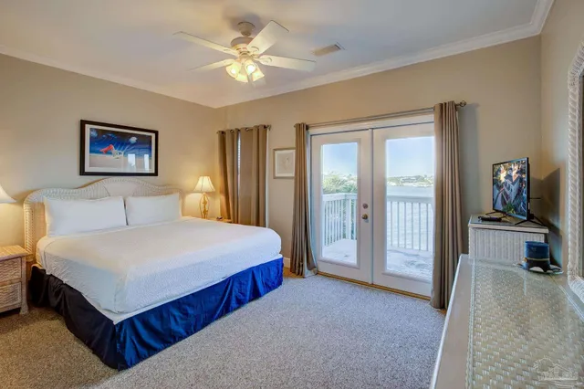 a spacious bedroom with a bed a rug and a chandelier