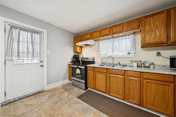 a kitchen with granite countertop a sink cabinets stainless steel appliances and a window