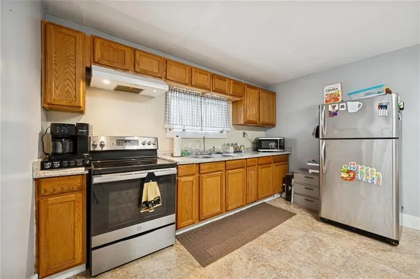 a kitchen with stainless steel appliances granite countertop a stove a sink and a refrigerator