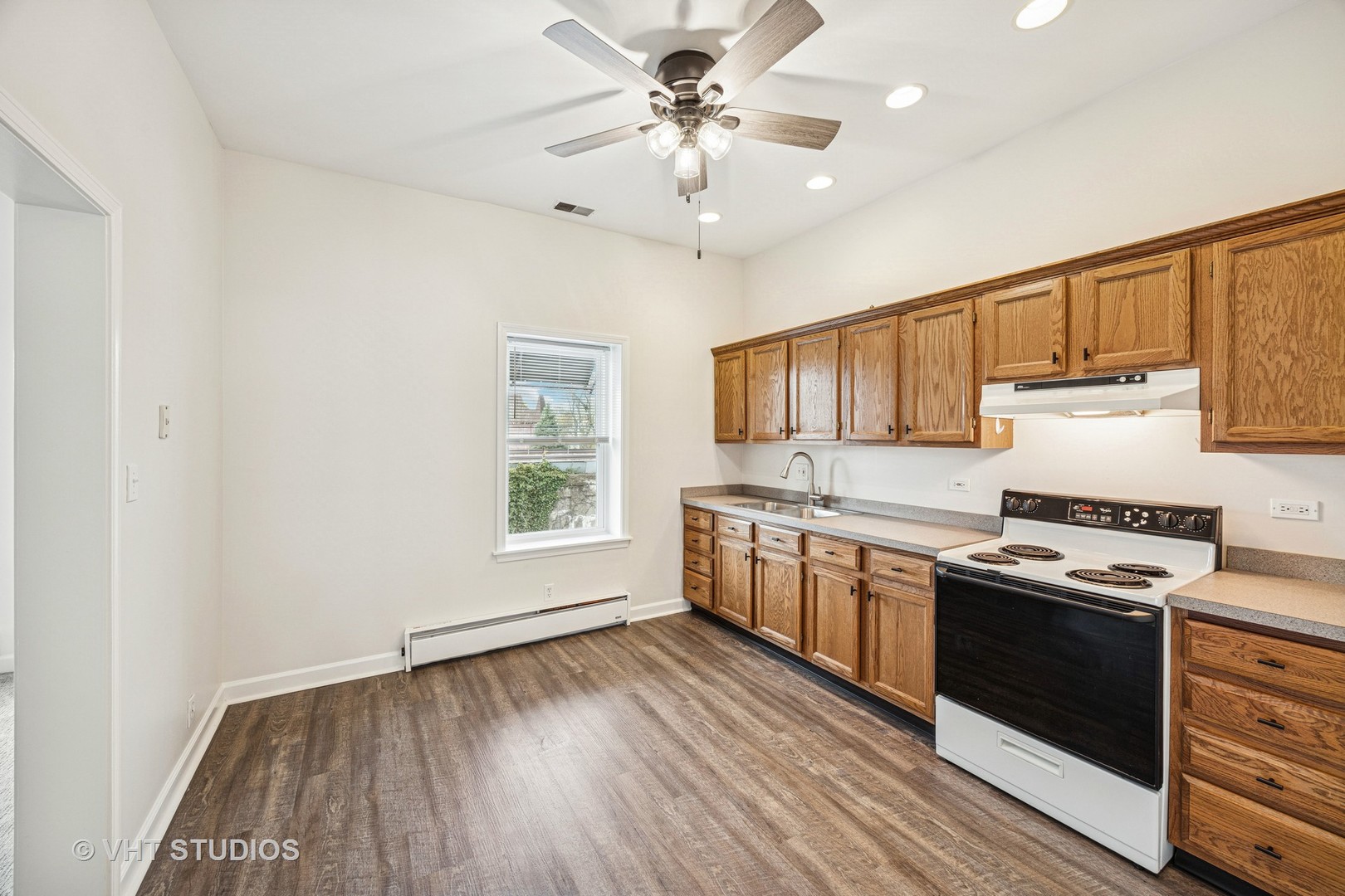816 North Boulevard, Unit 2F Oak Park, IL 60301 - Photo 10 of 20 a kitchen with stainless steel appliances a stove a sink dishwasher a refrigerator white cabinets and wooden floor next to a window