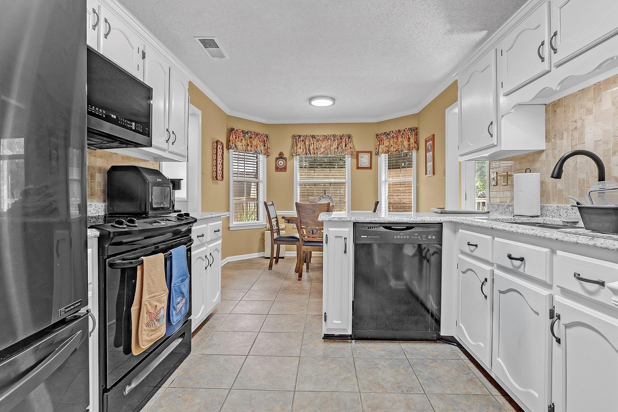 4020 Altruria Road Bartlett, TN 38135 - Photo 7 of 25 Kitchen featuring white cabinetry, light-colored countertops, and tile flooring
