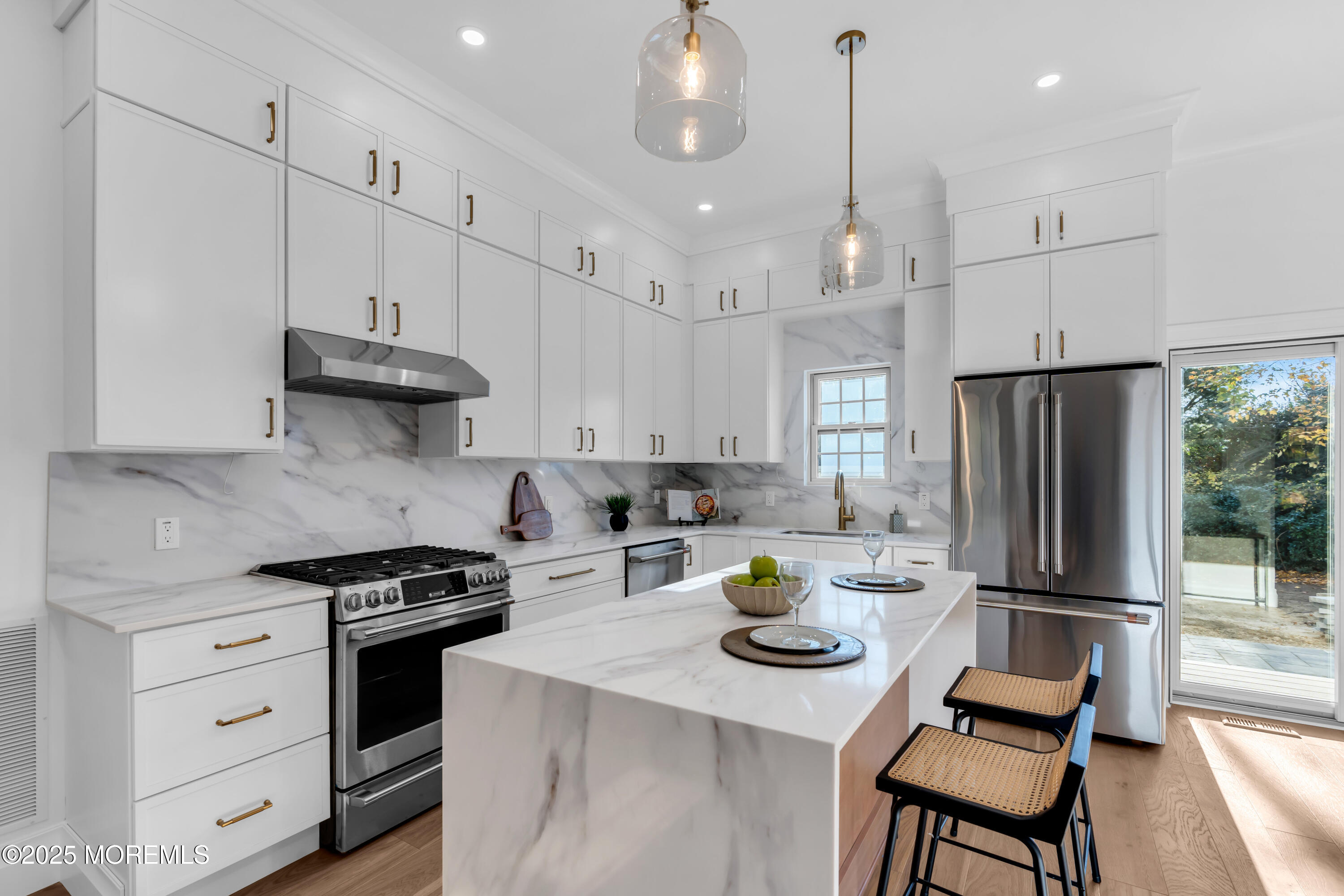 a kitchen with a refrigerator a stove a white table and chairs