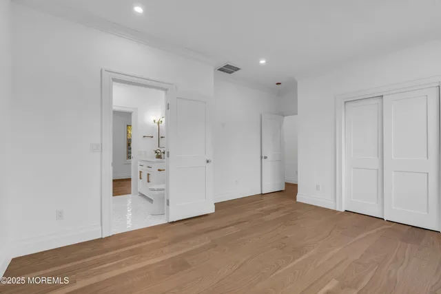 a view of a big room with wooden floor and windows