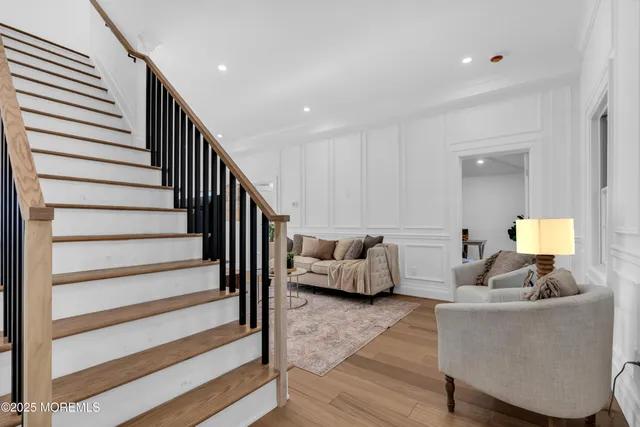 a living room with furniture and a lamp with wooden floor