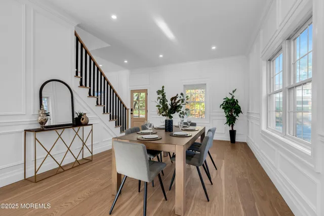a dining room with furniture potted plants and wooden floor