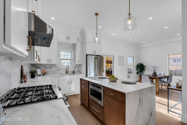 a kitchen with stainless steel appliances a stove a sink a microwave a refrigerator and cabinets