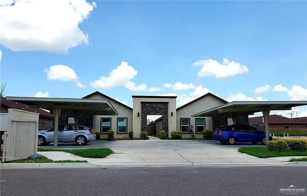 a front view of a house with a garden and parking