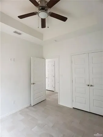 an empty room with chandelier fan