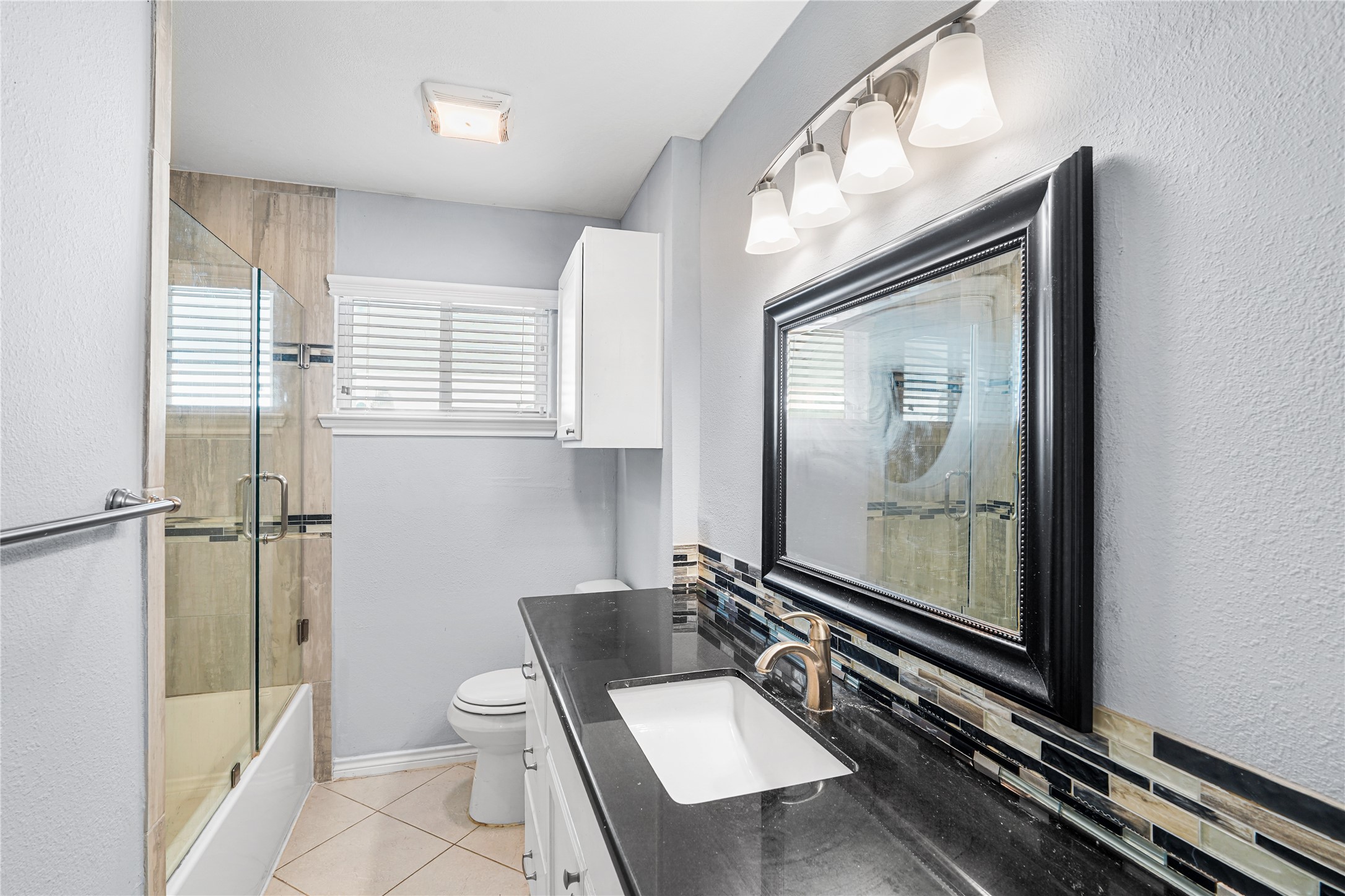6002 McKnight Street Houston, TX 77035 - Photo 13 of 28 a bathroom with a toilet a sink and mirror