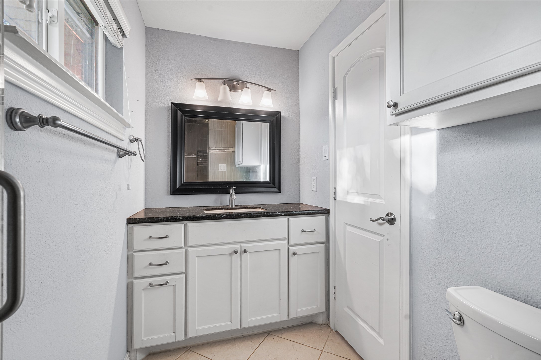 6002 McKnight Street Houston, TX 77035 - Photo 24 of 28 a bathroom with a toilet sink and mirror
