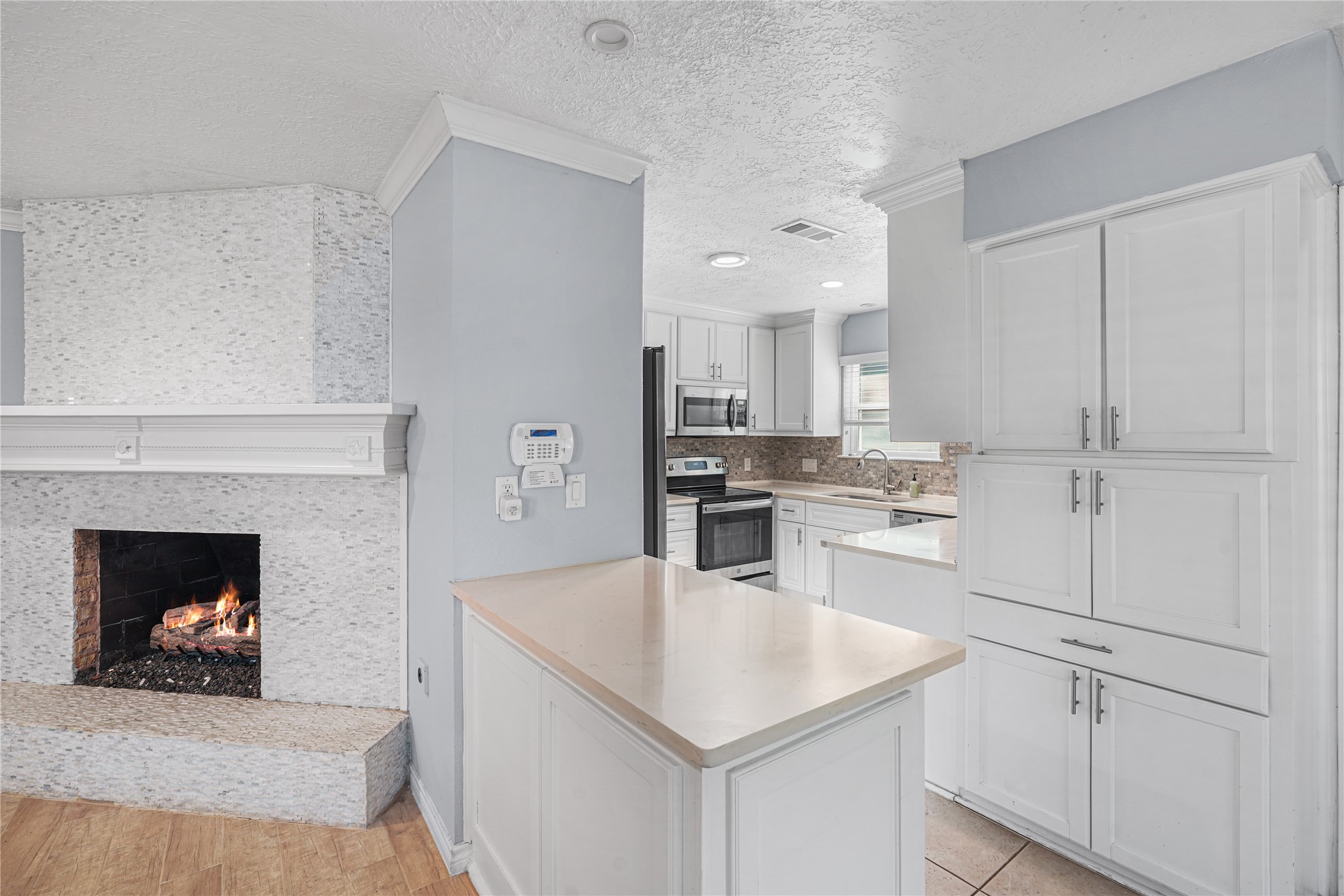 6002 McKnight Street Houston, TX 77035 - Photo 9 of 28 a kitchen with white cabinets and stainless steel appliances