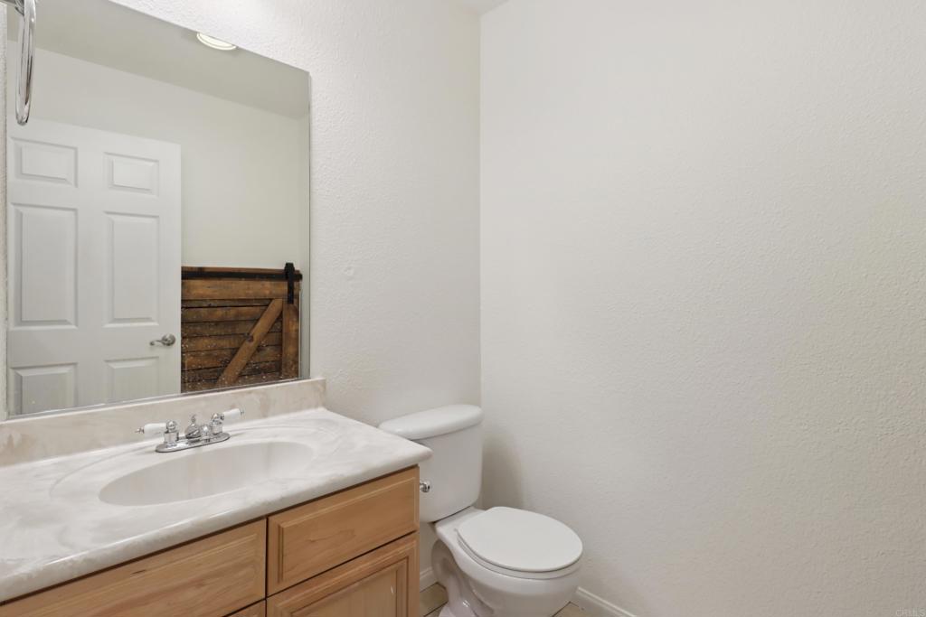 2140 Alpine Glen Place Alpine, CA 91901 - Photo 16 of 34 a bathroom with a granite countertop toilet and sink