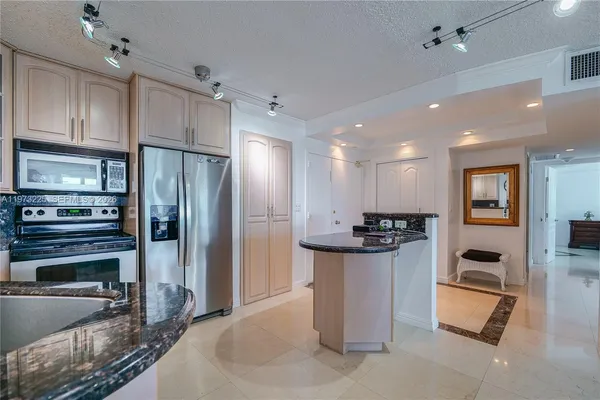 a kitchen with stainless steel appliances granite countertop a sink a stove and a refrigerator