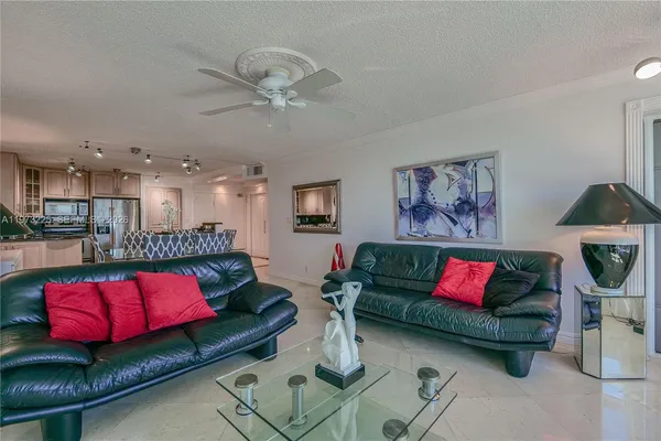 a living room with furniture kitchen view and a rug