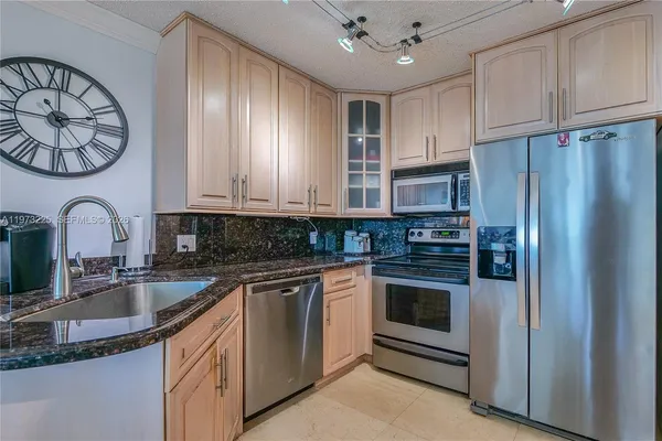 a kitchen with stainless steel appliances granite countertop a sink stove and refrigerator
