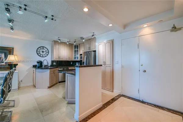 a kitchen with stainless steel appliances kitchen island granite countertop a refrigerator and a stove