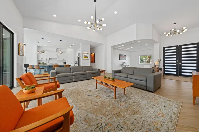 a living room with furniture a chandelier and a dining room