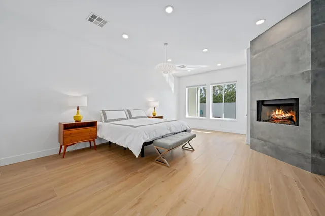 a spacious bedroom with a bed and a fireplace