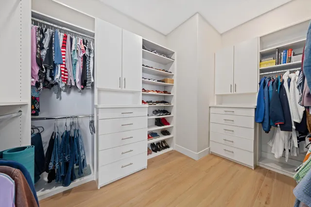 a view of walk in closet with clothes and shoes