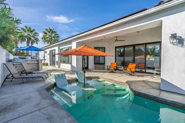 a swimming pool view with a seating space and a garden