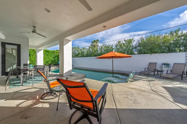 a patio with a table and chairs under an umbrella