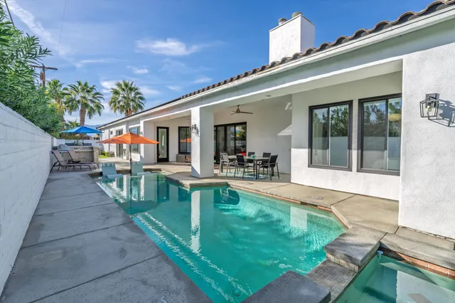 a view of a house with swimming pool and sitting area