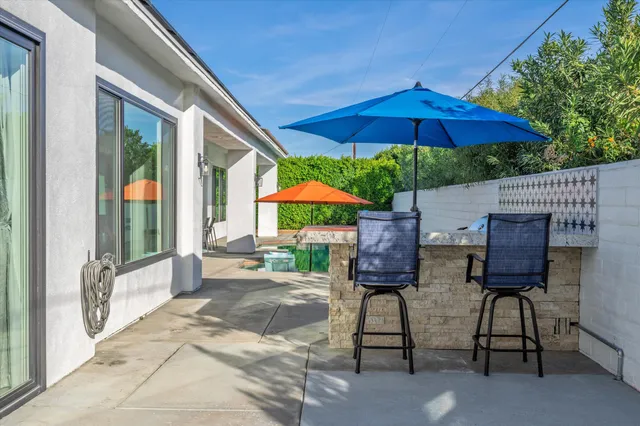 a view of patio with chairs and table under an umbrella